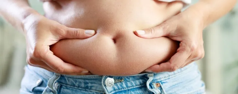 Woman receiving red light body sculpting for stubborn belly fat in Nashua NH